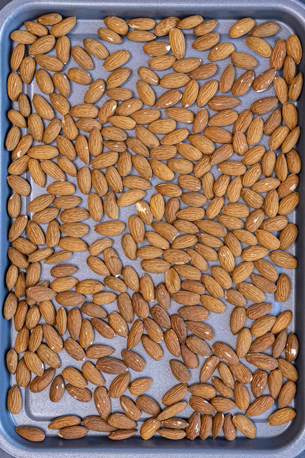 Raw almonds on a small baking sheet.