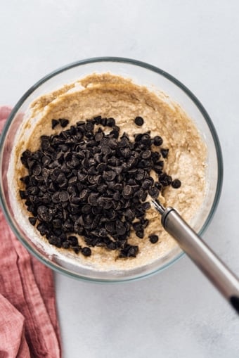 Chocolate chips on the ingredients in a mixing bowl for a pancake recipe without eggs