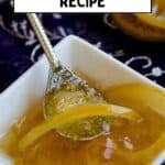 Spoon lifting lemon jam with lemon peel pieces from a small bowl.
