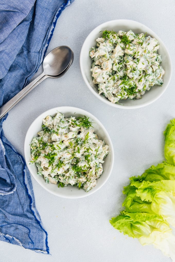 Low carb chicken salad recipe with Greek yogurt, mayo, walnuts, herbs and mustard in two white bowls. 