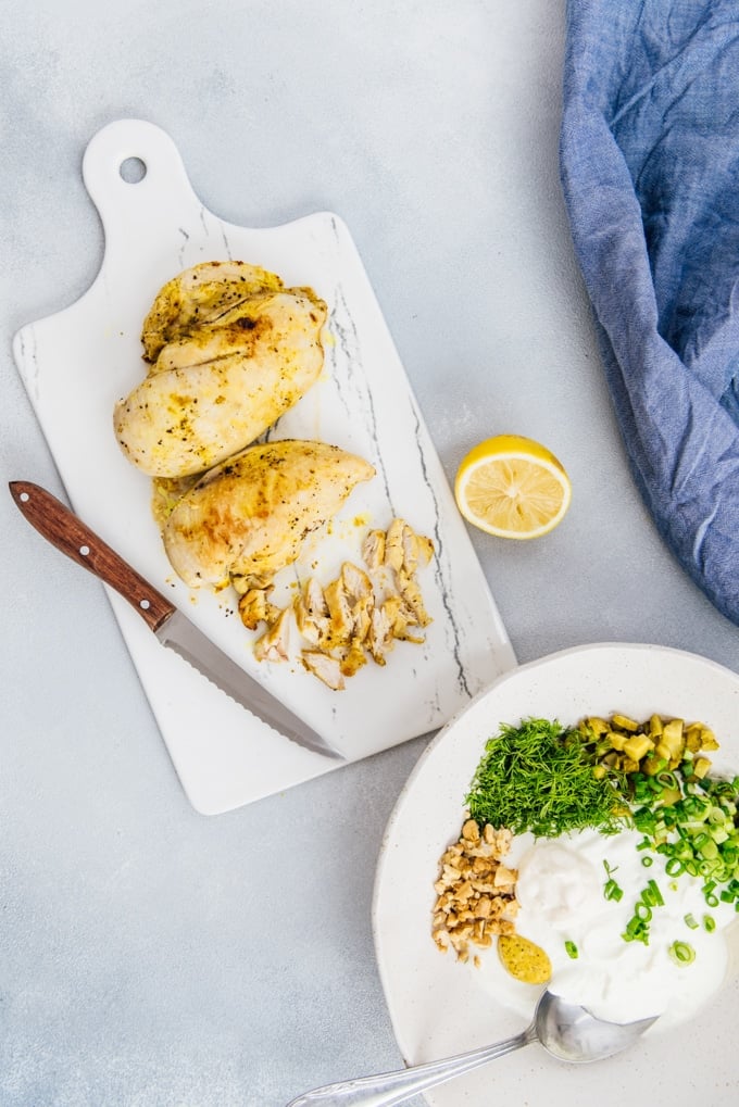 Low carb chicken salad recipe with herbs and walnuts makes a satisfying lunch with lettuce leaves. So easy to make! #chickensalad #lowcarbsalad #lowcarbchickensalad Pan roasted chicken breast sliced on a marble board to make a low carb curry chicken salad recipe