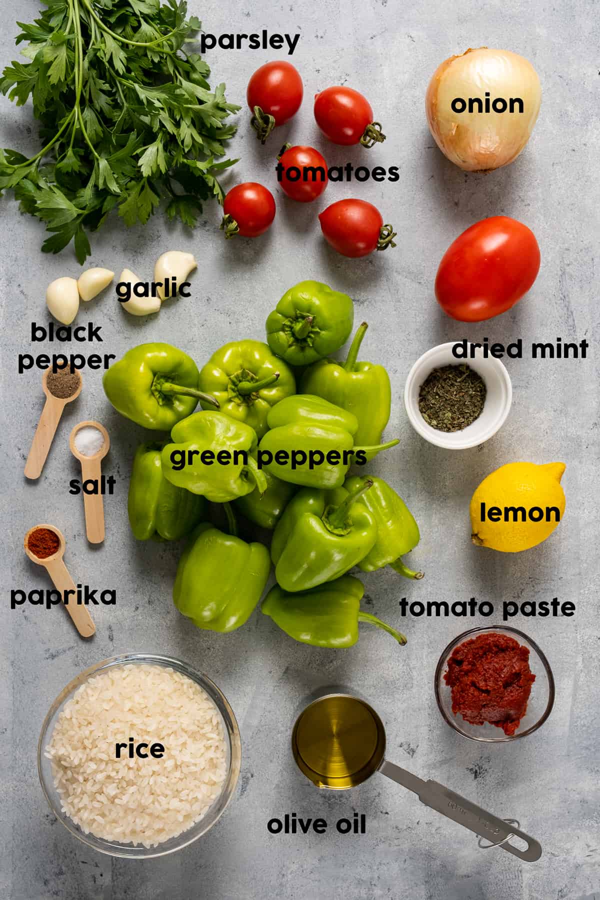 Turkish peppers, tomatoes, garlic, parsley, tomato paste, rice, spices, lemon, onion and olive oil on a light background.