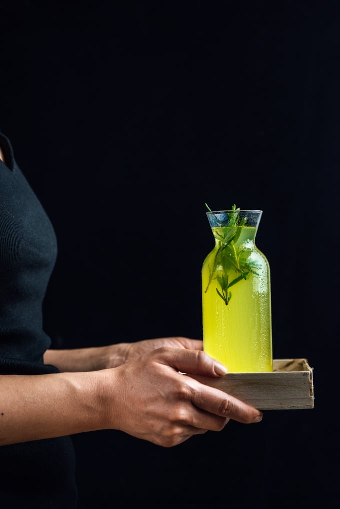 Woman holding a bottle of vodka lemon cocktail