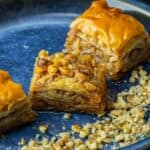 Turkish baklava with walnuts, layered phyllo dough and syrup, served on a plate.