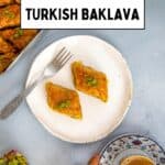 Turkish baklava on a plate with coffee and tray in background.