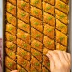 Tray of Turkish baklava topped with ground pistachios.