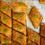 Tray of Turkish baklava with pistachio topping.