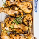 Oven baked chicken legs with herbs and garlic in a baking pan