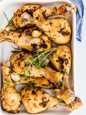 Oven baked chicken legs with herbs and garlic in a baking pan