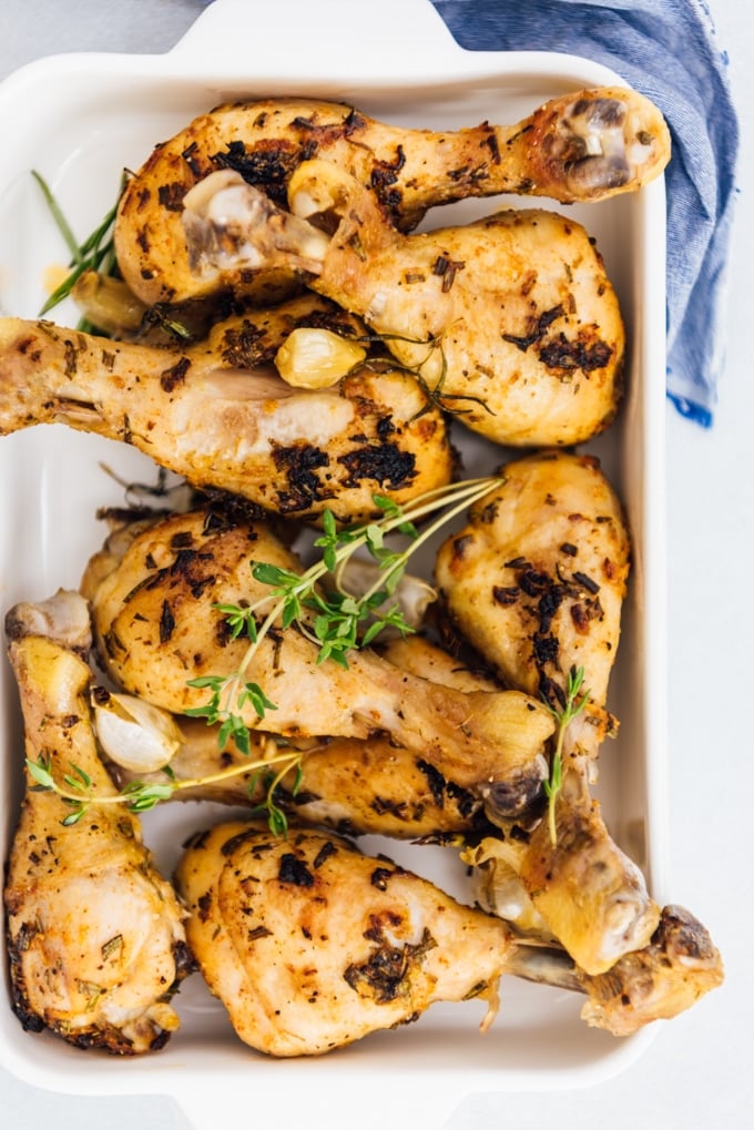Oven baked chicken legs with herbs and garlic in a baking pan 