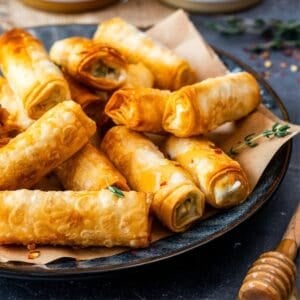 Crispy Turkish sigara boregi filled with cheese and herbs, served on a plate.