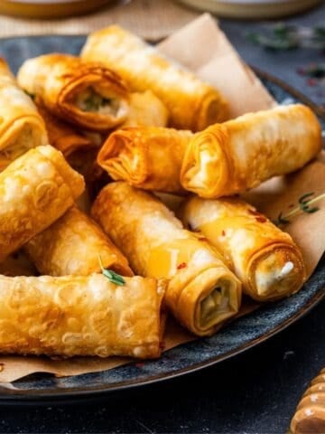 Crispy Turkish sigara boregi filled with cheese and herbs, served on a plate.