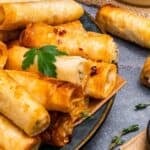 Crispy Turkish sigara boregi rolls filled with cheese, served on a plate.