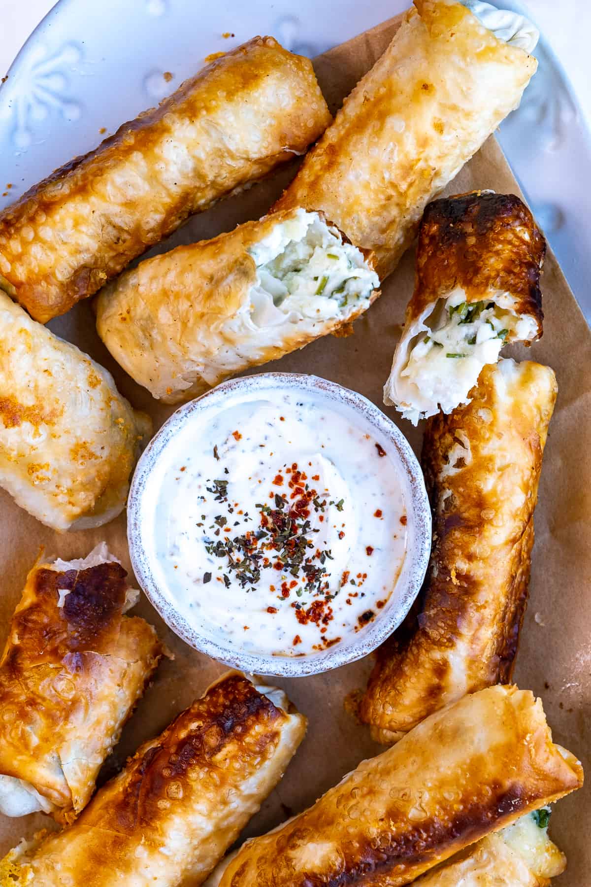 Cheese rolls served with a small bowl of yogurt sauce.