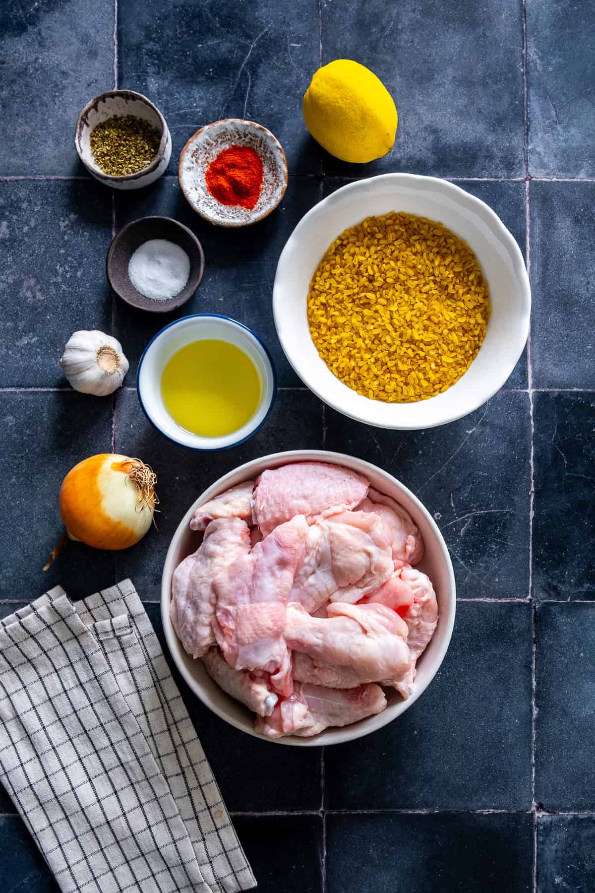 Chicken wings with bulgur ingredients including garlic, onion, lemon, olive oil, oregano and paprika.