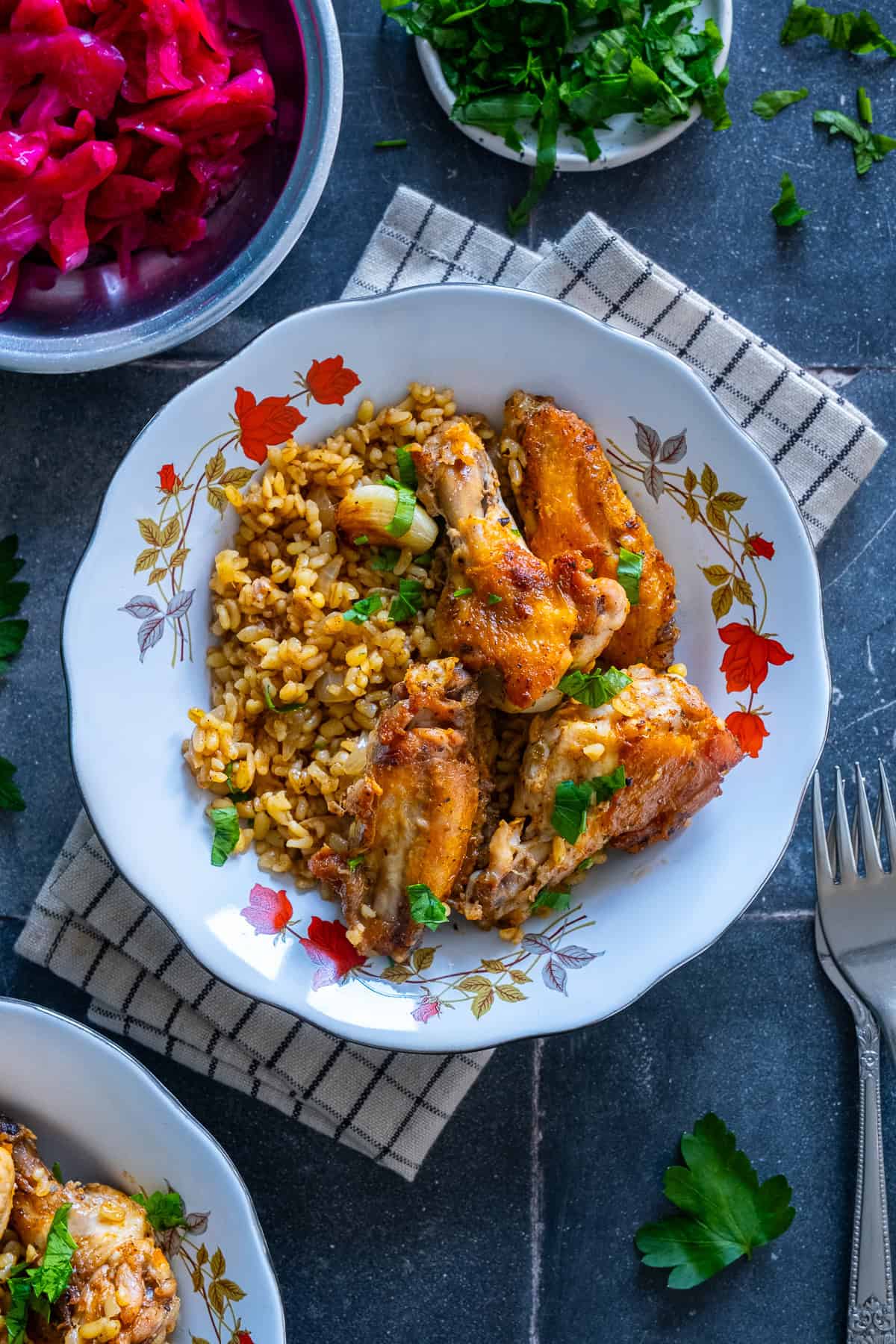 Close-up of chicken wings with bulgur, garlic and fresh parsley.