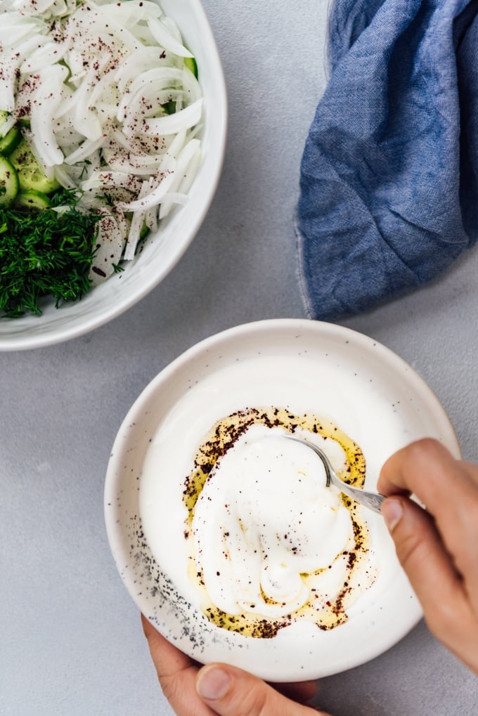 The BEST Creamy Cucumber Salad with onions and yogurt dressing. No mayonnaise. This will be your new summer hit! #creamycucumbersalad #cucumbersalad #saladwithoutmayo #creamycucumbers Creamy cucumber salad dressing with Greek yogurt, olive oil and sumac