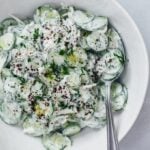 Creamy cucumber salad with a yogurt and sumac dressing in a white salad bowl