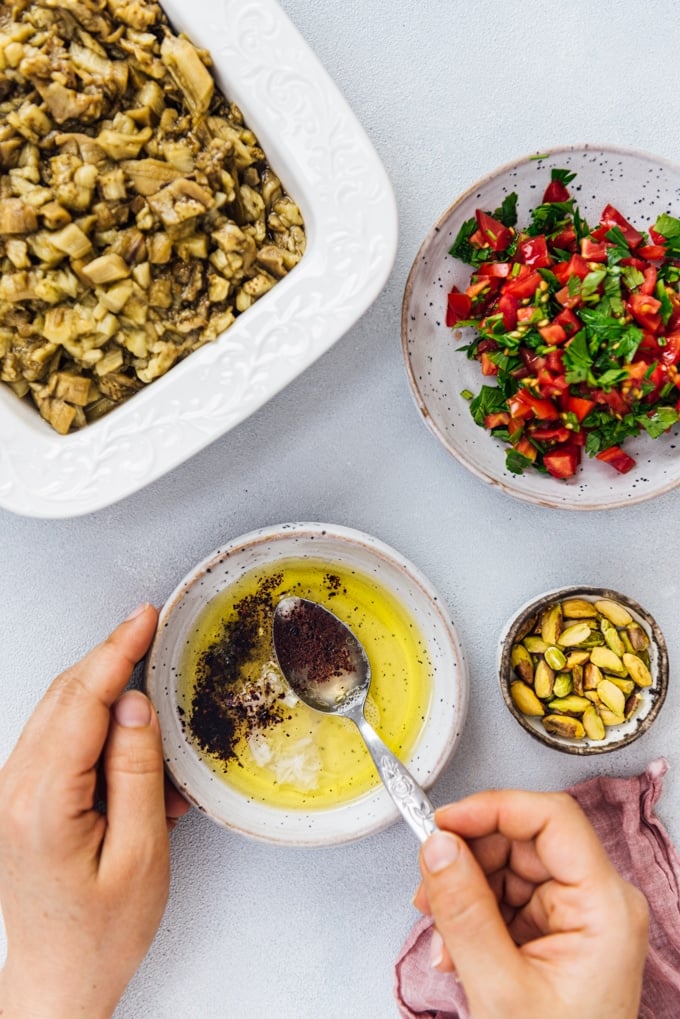 Woman making an olive oil and vinegar salad dressing for Turkish eggplant meze