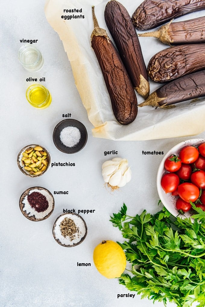 Turkish Eggplant Salad is the yummiest summer lunch when combined with a tangy dressing and topped with fresh summer tomatoes. #eggplantrecipe #eggplant #roastedeggplant #turkishsalad #turkishrecipe Grilled eggplant salad recpe ingredients on a grey background