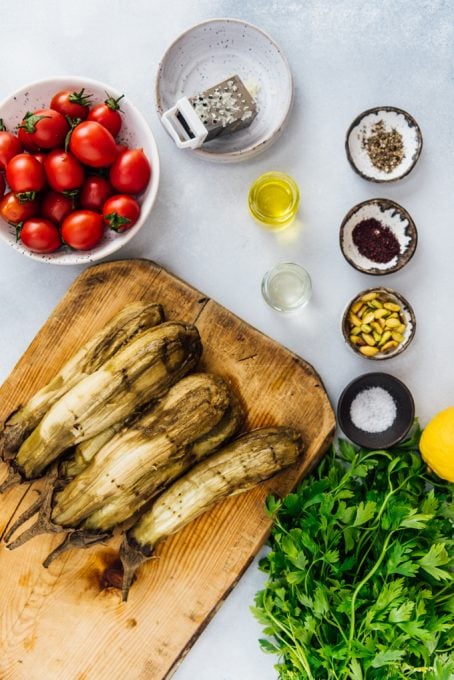 Roasted eggplant salad ingredients on a grey background