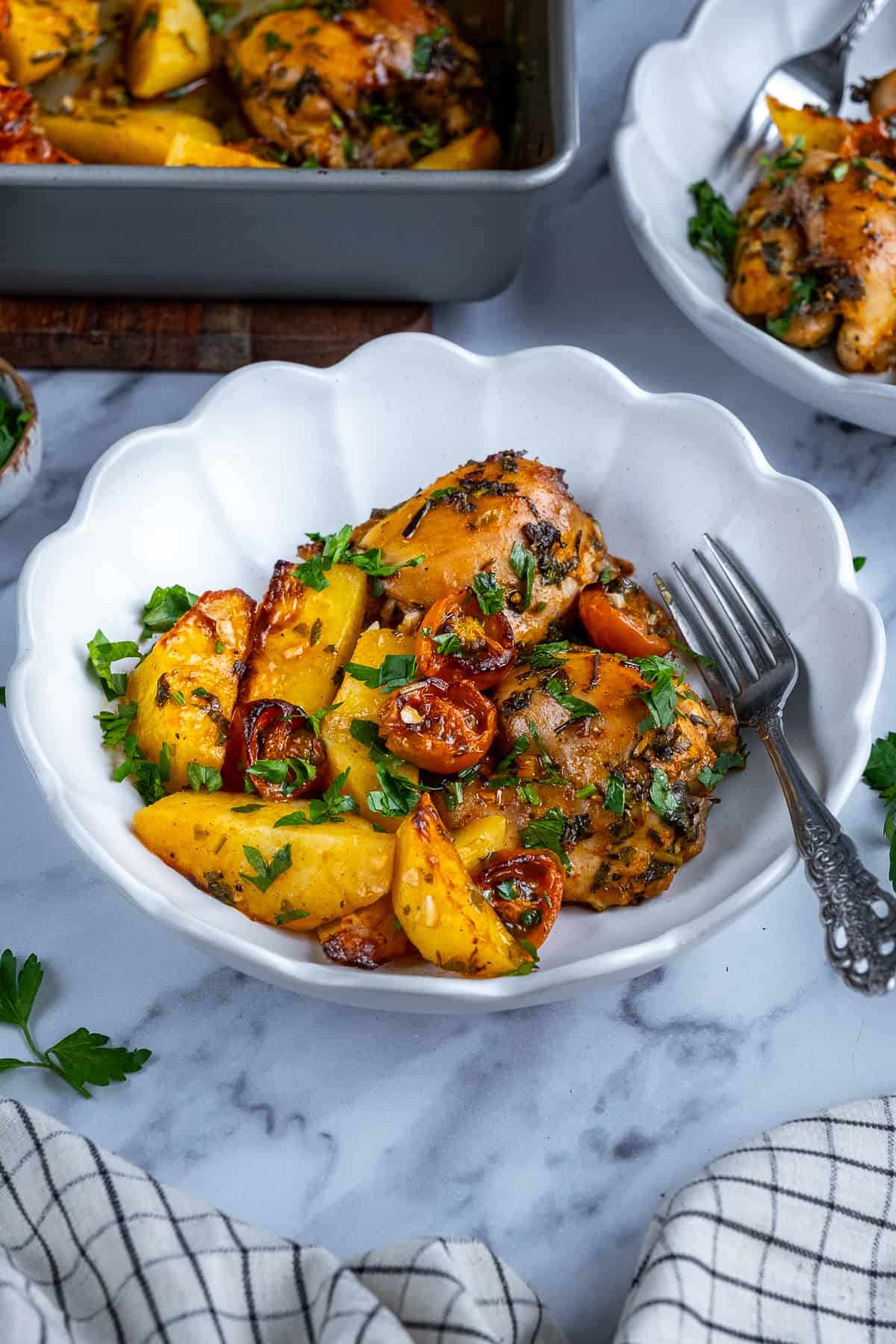 Baked chicken and potatoes in a white bowl.