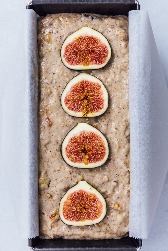 Banana Fig Bread is a PERFECT vegan loaf cake for breakfast. It is sugar free yet so yummy and easy to make. #veganbread #loafcake #figbread #bananabread #sugarfreebaking Banana fig loaf cake batter in a loaf pan topped with fresh fig slices.