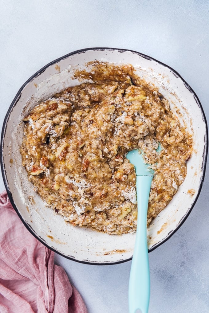 Healthy fig loaf with banana batter in a ceramic bowl with a spatula in it.