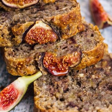 Vegan fresh fig bread with walnuts sliced on a ceramic plate.