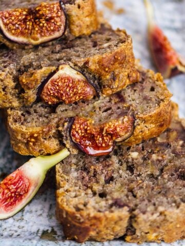 Vegan fresh fig bread with walnuts sliced on a ceramic plate.