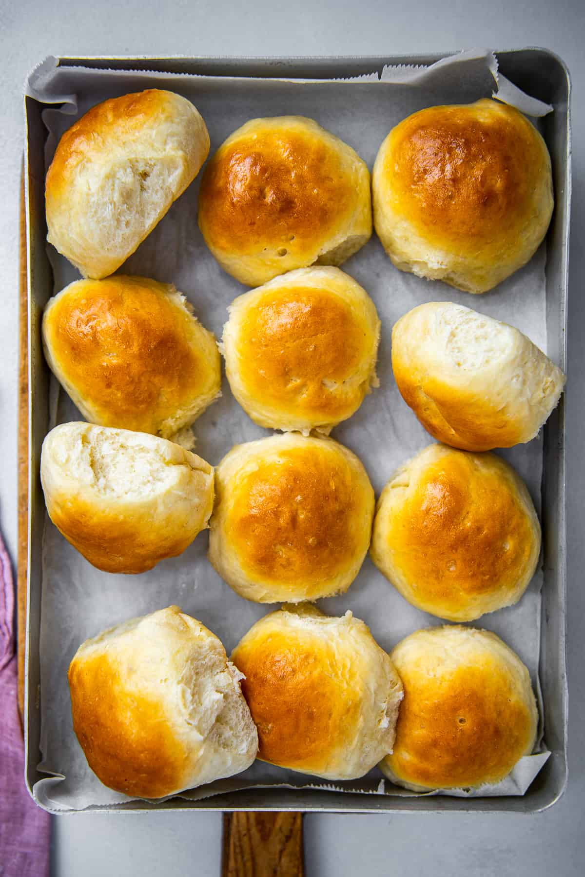 Homemade bread rolls in a baking tray.