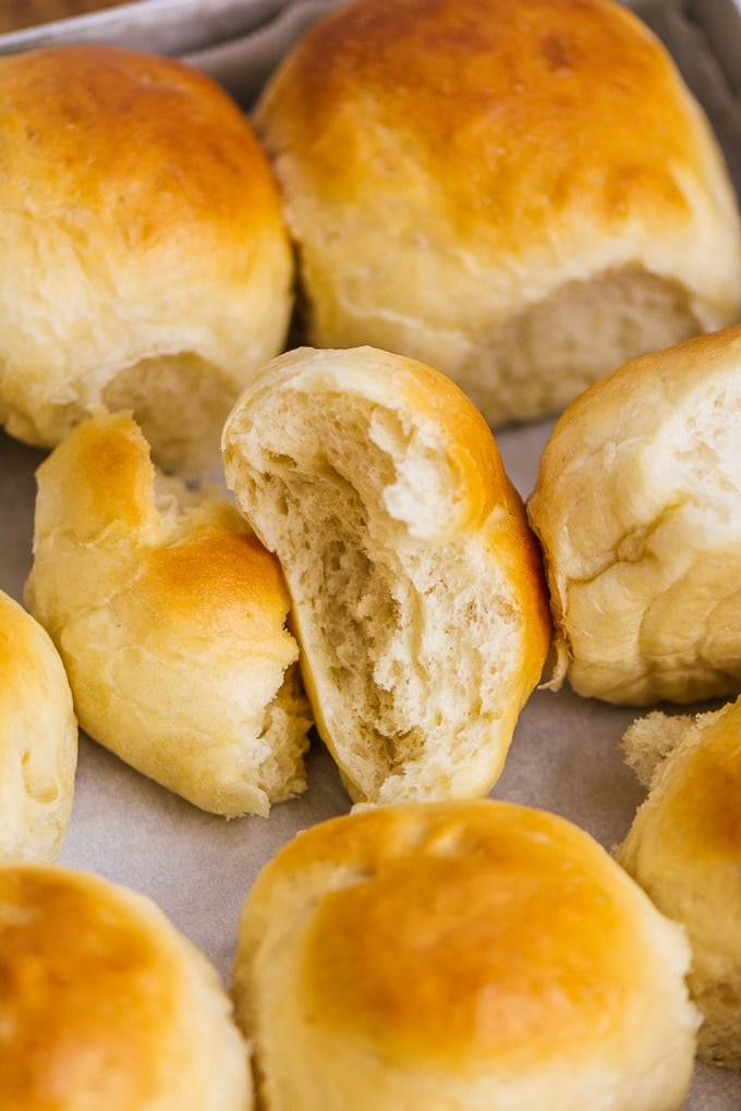 These classic homemade dinner rolls are wonderfully SOFT and fluffy. The best recipe that works perfectly every time! #dinnerrolls #yeastrolls #bakingbread #breadrollrecipe Buttery and fluffy yeast rolls on a baking sheet.