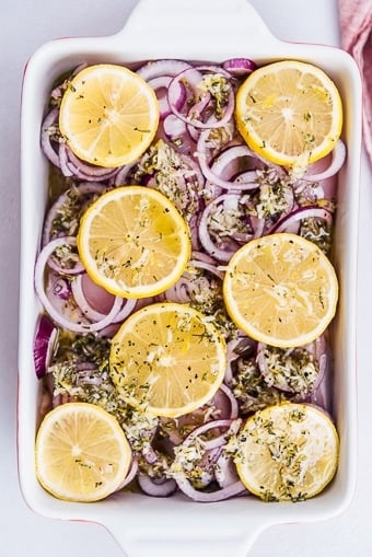 chicken with lemon slices, onions and lemon sauce to be baked