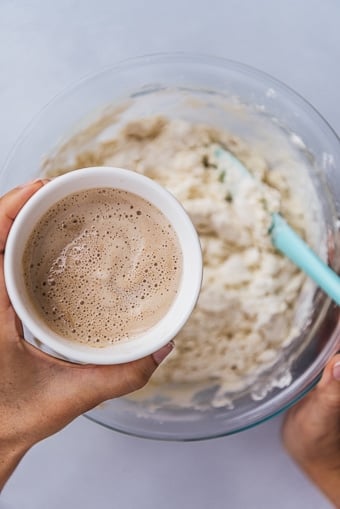 combining yeast and other ingredients in a large bowl to make a bread roll recipe