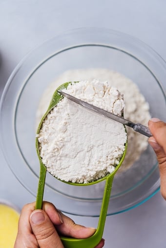 measuring flour with a cup and a knife
