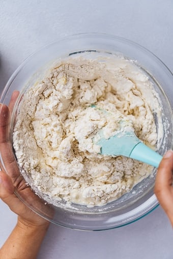 making dinner roll dough in a large glass bowl