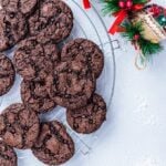 Chocolate cake mix cookies on a cooling rack with Christmas decorations