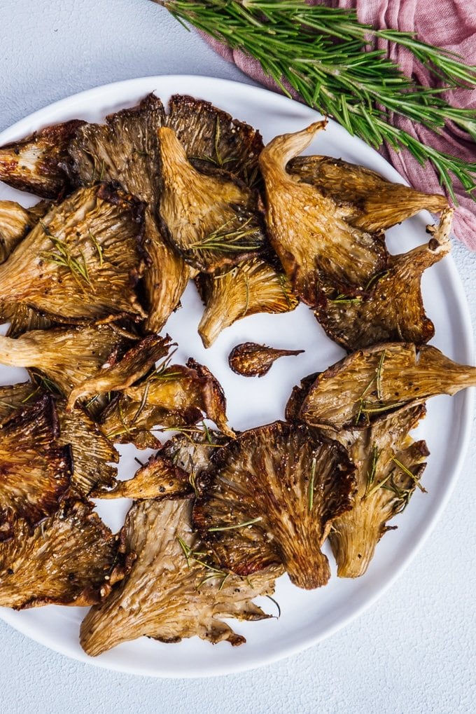Roasted oyster mushrooms with rosemary served on a white plate
