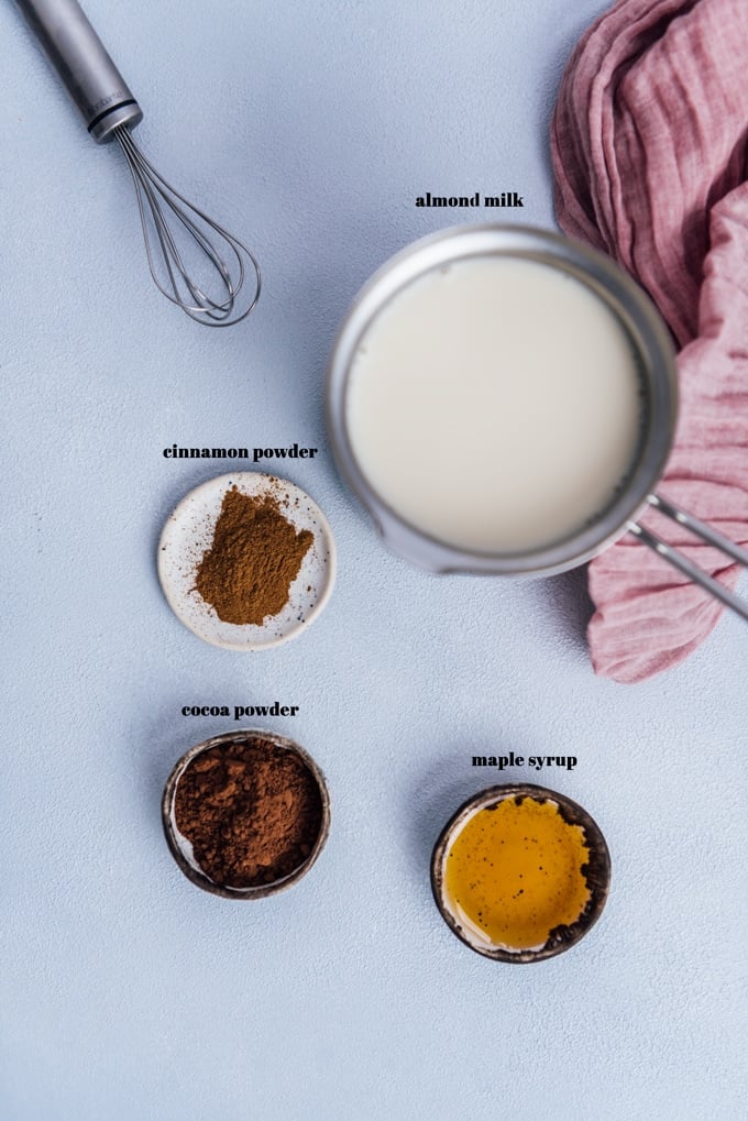 ingredients for hot chocolate with almond milk on a grey background