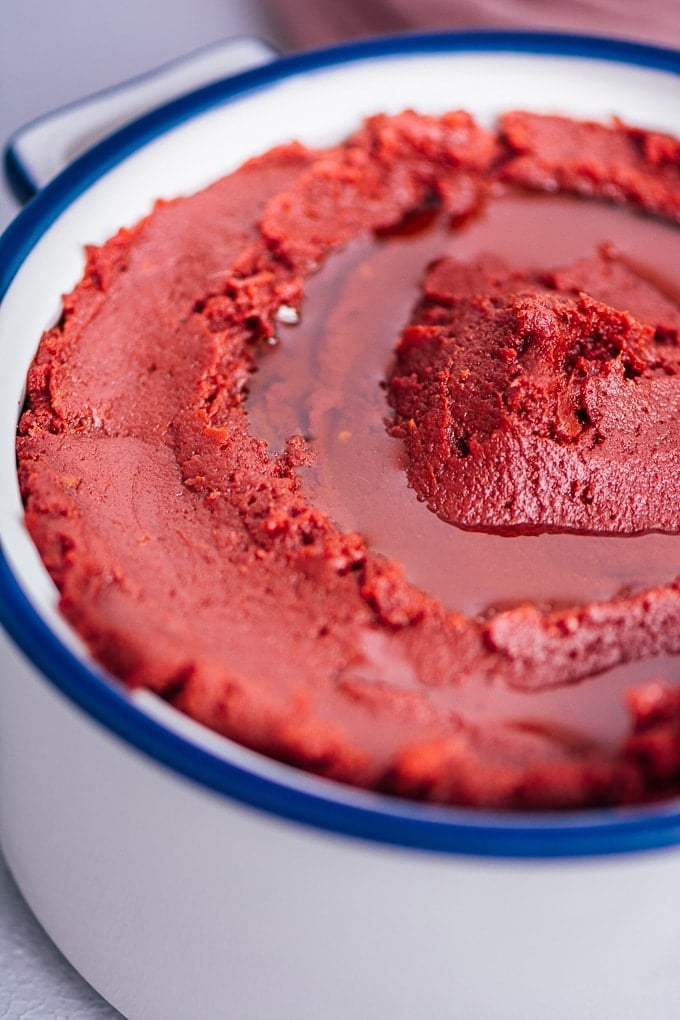 Tomato paste in a white bowl, drizzled with olive oil.