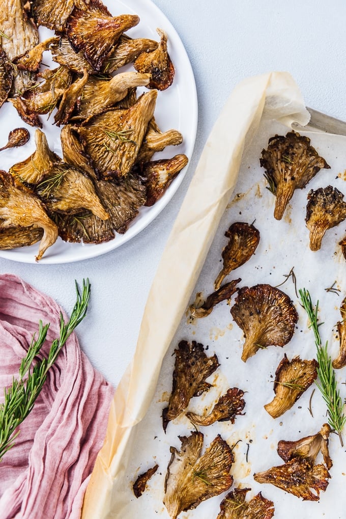 Oven roasted oyster mushrooms on a white plate and in a baking sheet