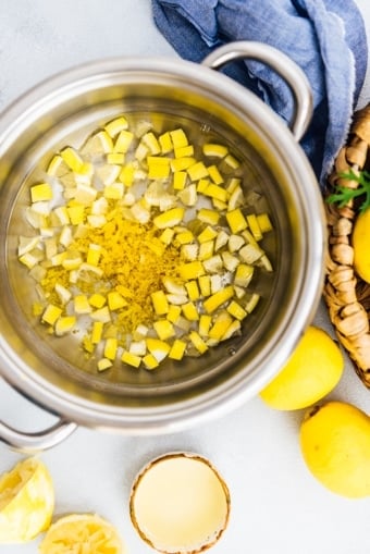Lemon zest and chopped lemon in a pot for lemon jam making.