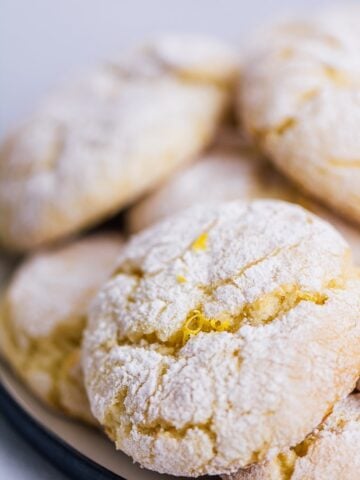 Lemon cake mix cookies stacked on a plate.