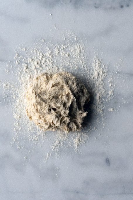 Bread dough without yeast on a marble counter.