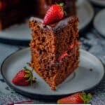 Chocolate cake slice with ganache and strawberry filling.