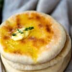 Bazlama Turkish flatbread stacked with melted butter on top, soft and golden.