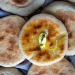 Bazlama Turkish flatbread with melted butter on top, soft and golden breads arranged on a tray.