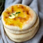 A stack of bazlama breads, melting butter and thyme on the top.