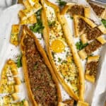 Ground meat pide and cheese pide with an egg topping in a baking tray.