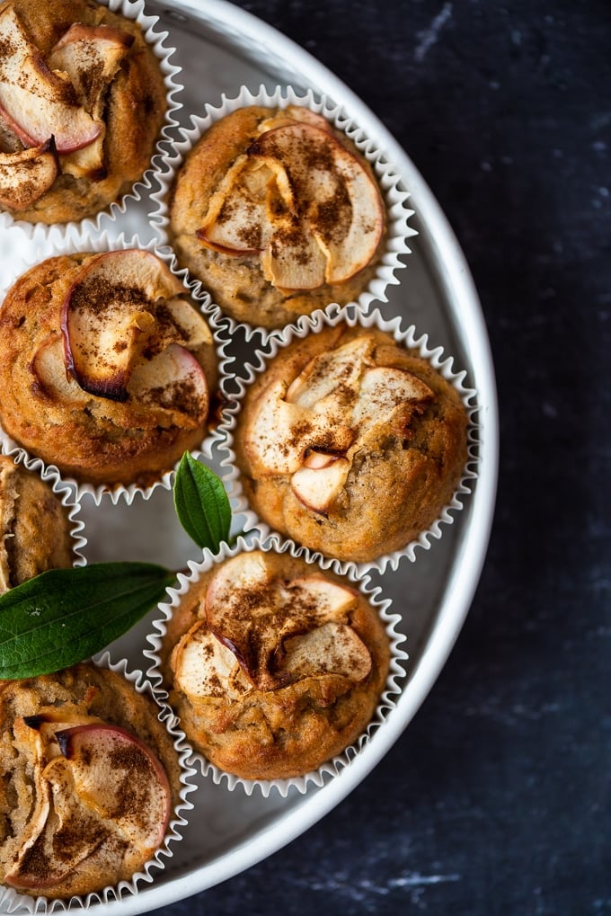 Apple cinnamon muffins in a white pan on a dark background